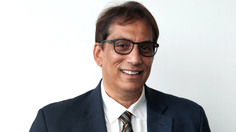 Dr. Iqbal Surve alongside BEE stock market graphs.